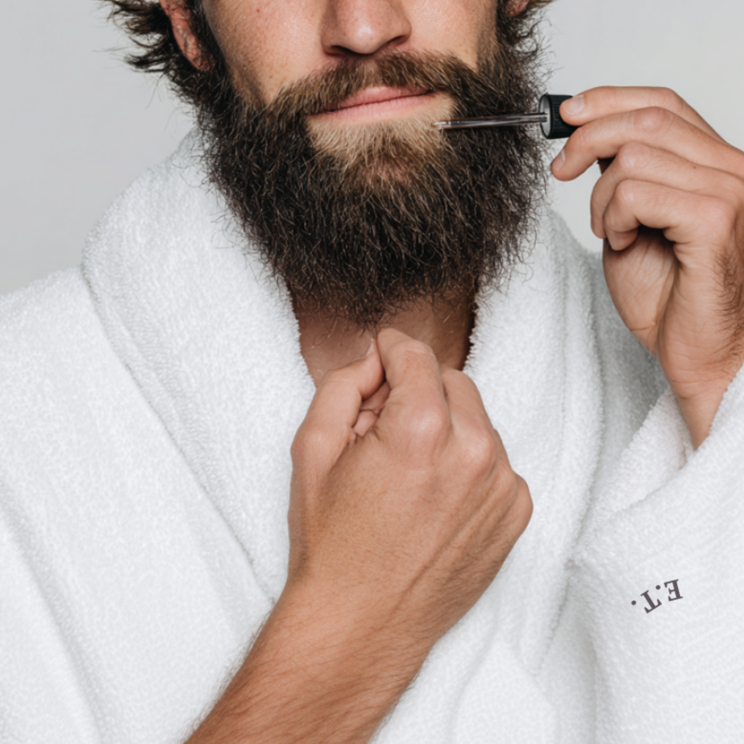 Hydrating beardoil for men being applied by conventionally attractive male model