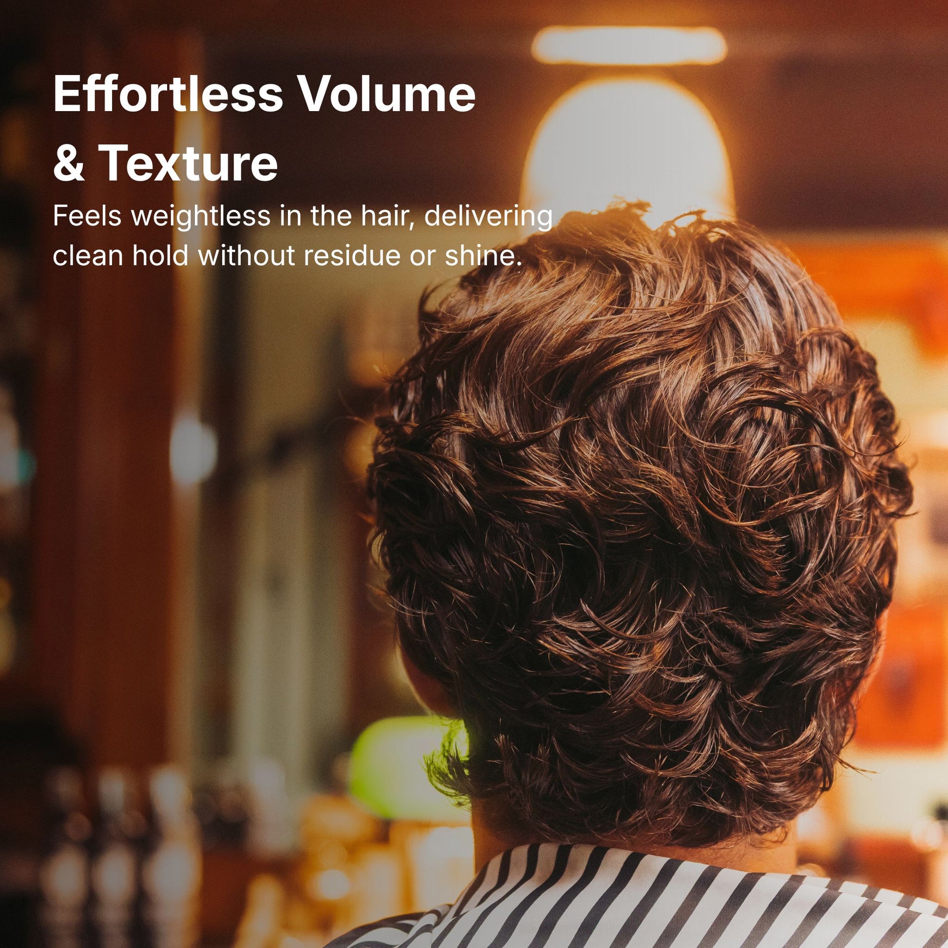 Person with styled hair in a blurred indoor setting, promoting effortless volume and texture.