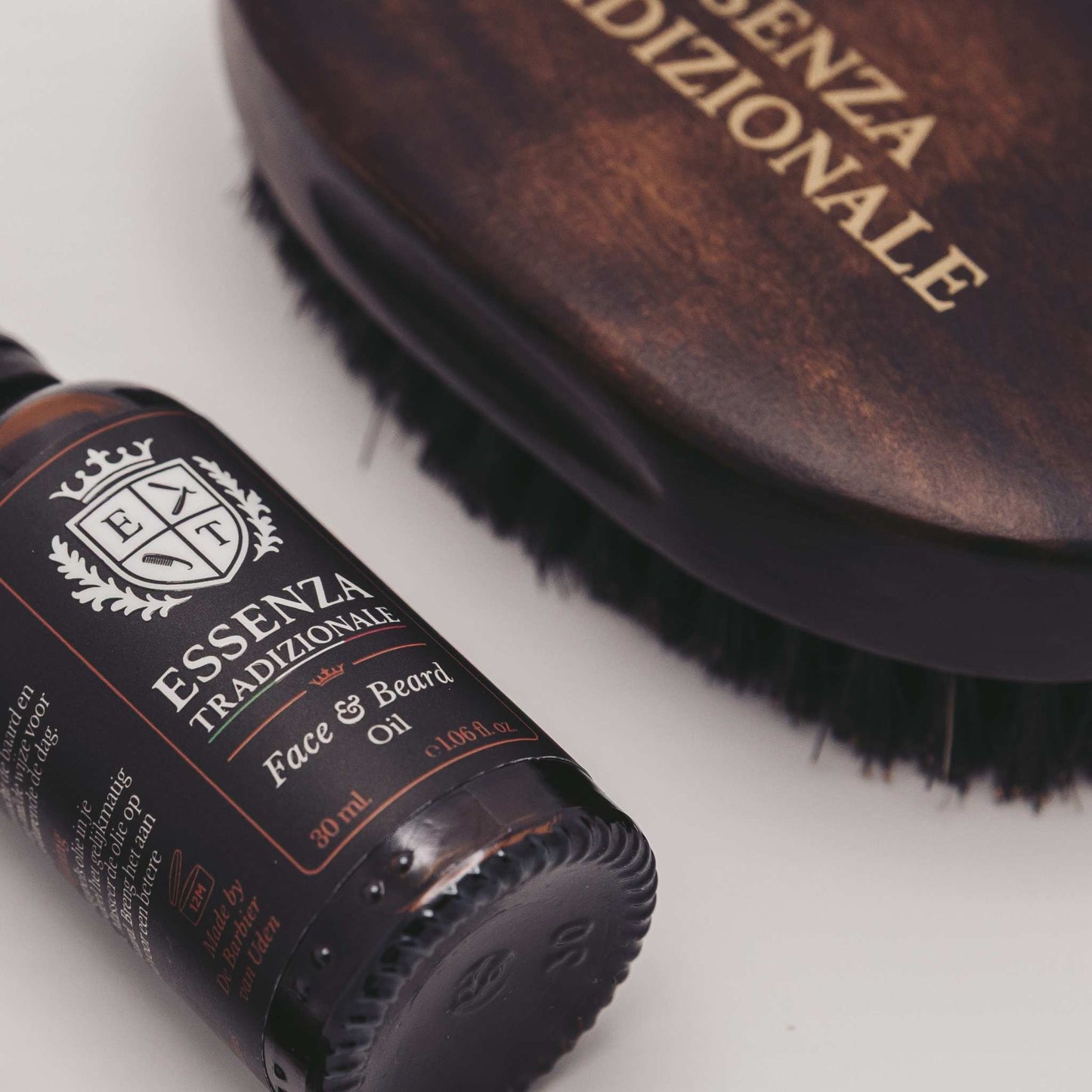 Bottle of Essenza Tradizionale face and beard oil with a brush on a white background