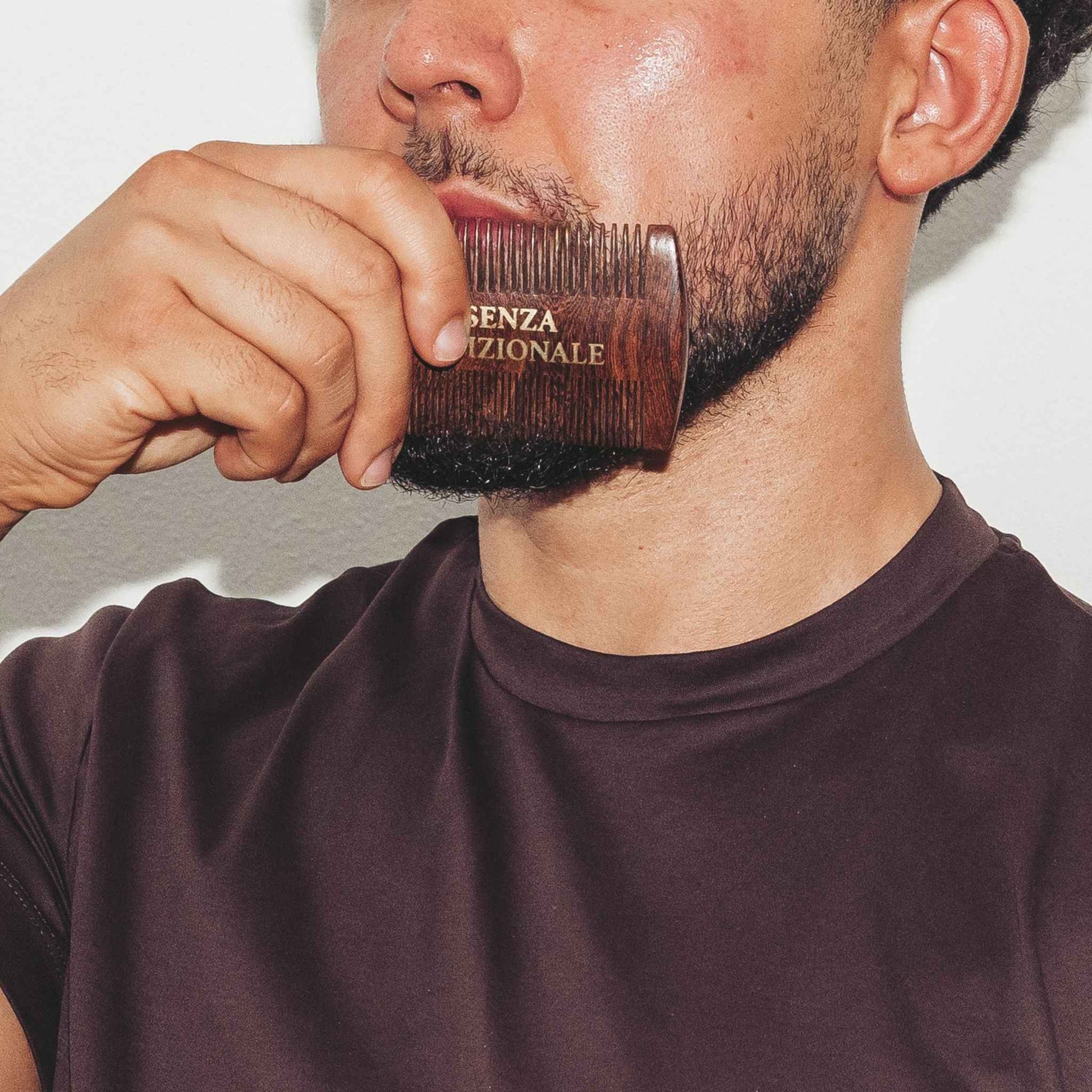 closeup of model brushing hair with essenza tradizionale wooden beard comb