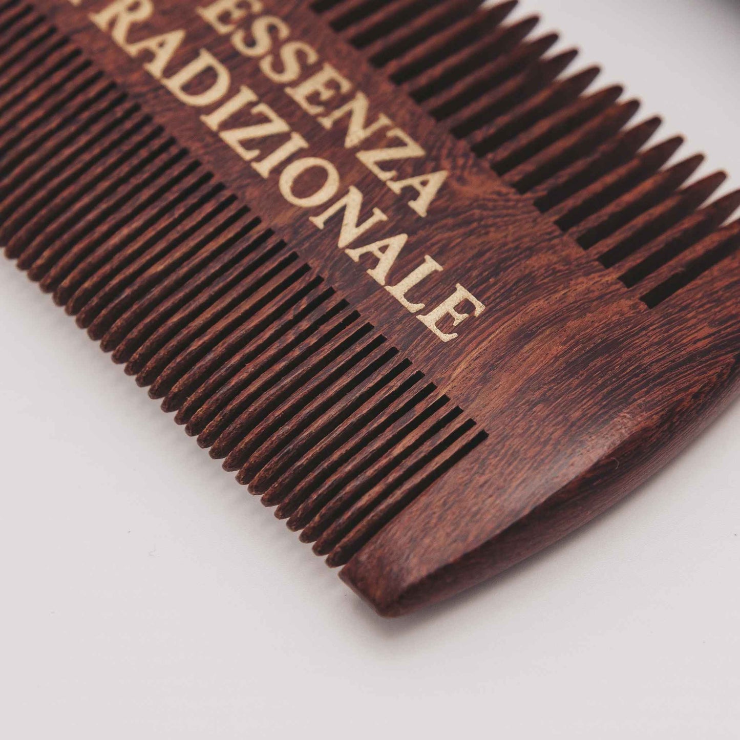 Wooden comb with 'ESSENZA TRADIZIONALE' branding on a light background