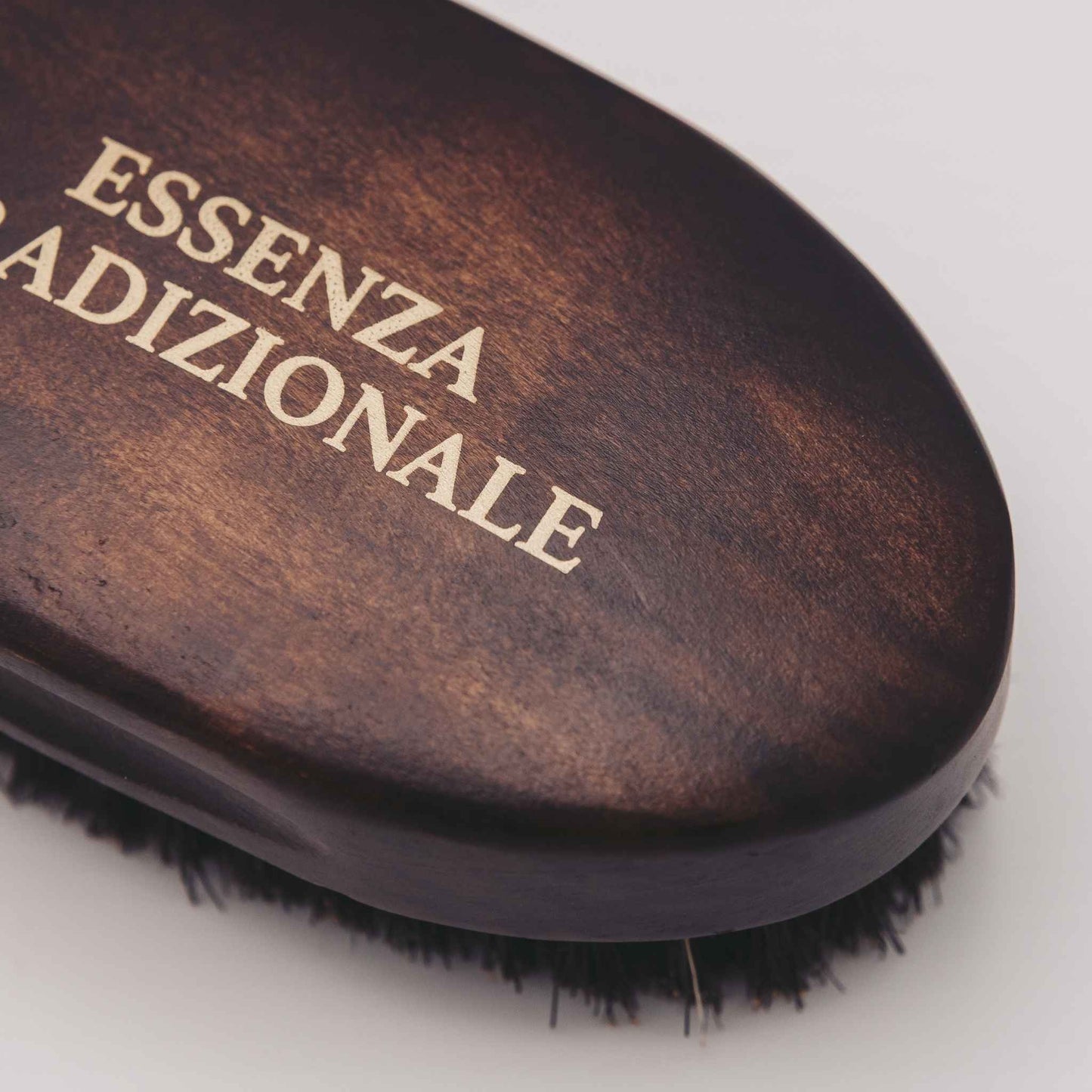 Wooden hairbrush with 'ESSENZA ADIZIONALE' branding on a white background