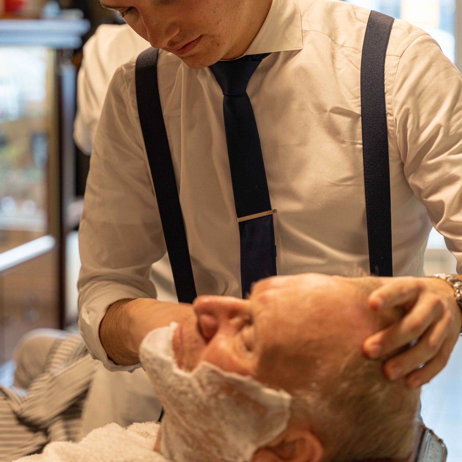 Man shaving another man in a barberchair